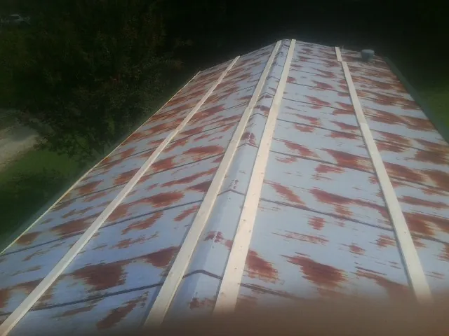 Rusted metal roof panels with new wood purlins before replacement — Storm Damage Roof Repair in Round Lake by Roofing Brothers